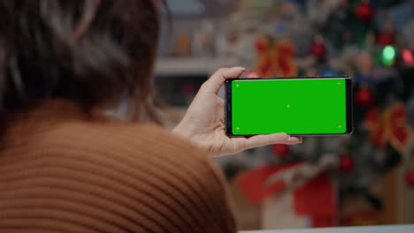 Young-woman-using-green-screen-smartphone