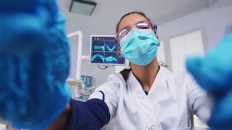 Patientensicht-Zum-Zahnarzt-In-Schutzmasken-Haltewerkzeugen