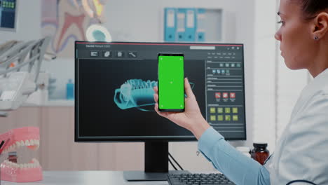 Frau-Arbeitet-Als-Zahnarzt-Mit-Grünem-Bildschirm-Auf-Dem-Smartphone