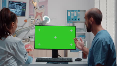 Dentist-and-man-nurse-analyzing-green-screen-on-computer