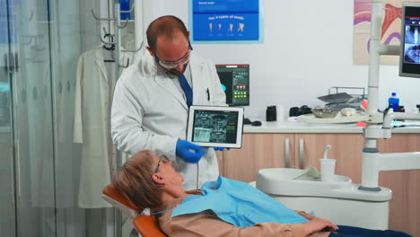 Ortodoncista-Con-Guantes-Sosteniendo-Una-Tableta-Que-Sugiere-Tratamiento