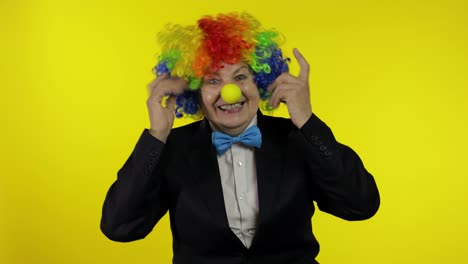 Senior-old-woman-clown-in-colorful-wig-smiling,-making-silly-faces,-fool-around