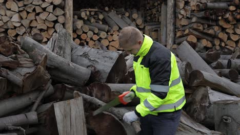 Lumberjack.-Man-woodcutter-use-small-saw.-Sawn-logs,-sawmill,-firewood-background.-Wood-harvesting