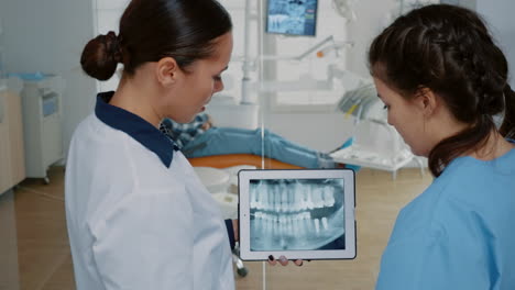 Stomatologist-holding-modern-tablet-with-x-ray-on-screen