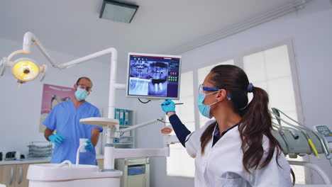 Dentist-doctor-and-patient-looking-at-digital-teeh-x-ray