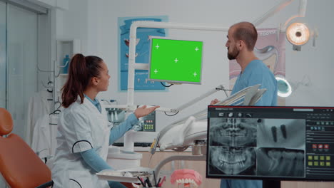 Dentist-and-assistant-looking-at-green-screen-on-monitor