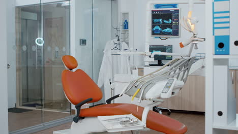 Revealing-shot-of-orthodontic-chair-with-nobody-in,-teeth-x-ray-images-on-modern-display
