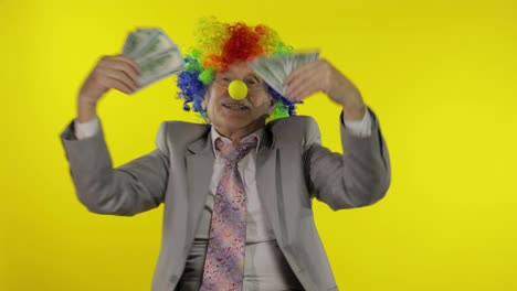 Älterer-Clown-Geschäftsmann,-Freiberufler,-Der-Mit-Geld-Dollar-Bargeldscheinen-Tanzt