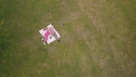 Family-weekend-picnic-in-park.-Aerial-view.-Senior-old-couple-lie-on-blanket-on-green-grass-meadow