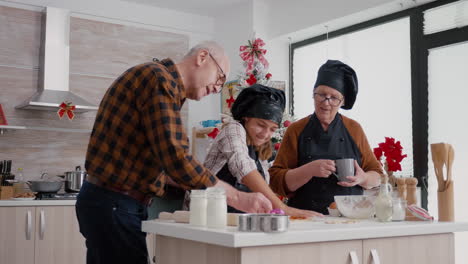 Grandparents-enjoying-spending-time-with-granddaughter-cooking-gingerbread-dessert