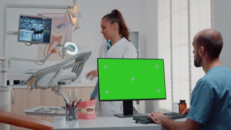 Assistant-using-horizontal-green-screen-on-computer