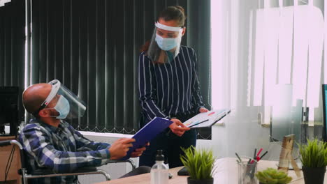 Paralysed-man-with-mask-working-at-financial-project-with-partner