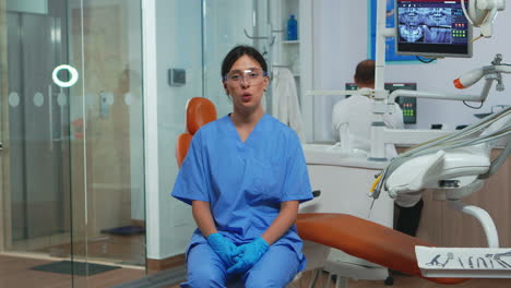 Dental-assistant-looking-at-camera-speaking-with-patients