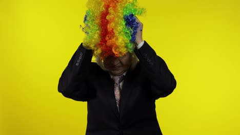 Senior-female-woman-in-business-suit-wears-clown-wig,-begin-working-and-smiling