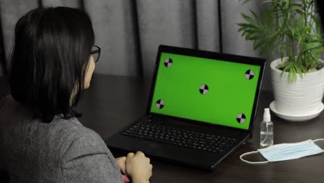 Woman-have-video-call-conference-on-laptop-with-green-screen.-Distance-work