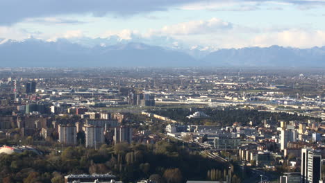 Snowy-peaks-of-Alps-and-Milan-city-bellow,-aerial-view