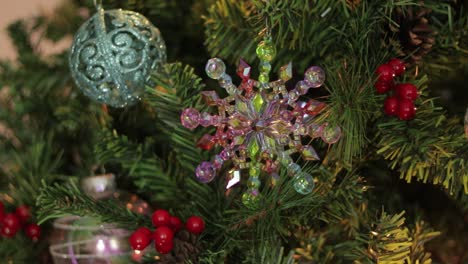 Putting-iridescent-rainbow-snowflake-decoration-on-christmas-tree
