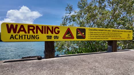 Warnschild-„Achtung“-Warnt-Davor,-Dass-In-Der-Gegend-Krokodile-Leben-Und-Angriffe-Zu-Verletzungen-Oder-Zum-Tod-Führen-Können