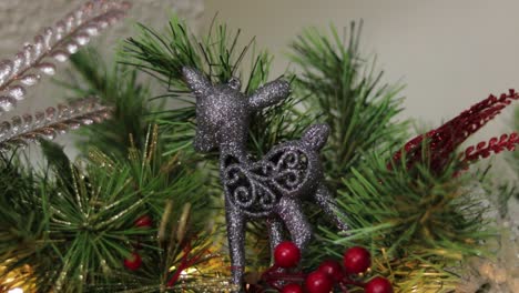 Grey-glitter-fawn-christmas-ornament-in-decorated-pine-tree-needles