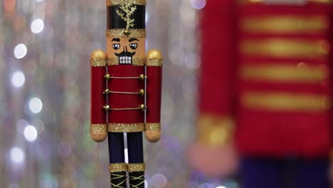 Toy-soldier-nutcracker-on-table,-same-but-huge-figurine-in-background