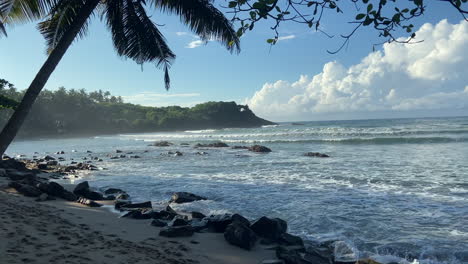 Establishing-Handheld-Static-Shot-of-Beach-and-Bay-on-South-Sri-Lanka-Coast-with-Palm-Trees-and-Rocks-Small-Waves-Hiriketiya-Beach