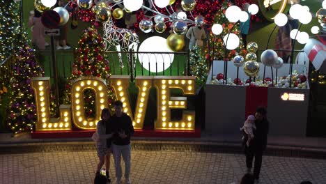 Young-couple-and-family-capturing-memories,-West-Kowloon-Christmas-decor