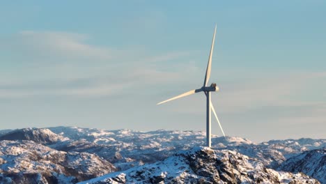 Cinematic-Drone-Shot-of-Windmills-and-Spinning-Blades-on-Top-of-Mountain-Range-on-Sunny-Winter-Day