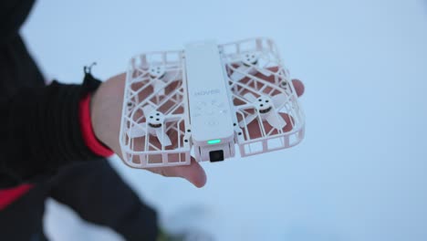 Small-white-Hoverair-X1-self-flying-camera-drone-on-palm-of-hand