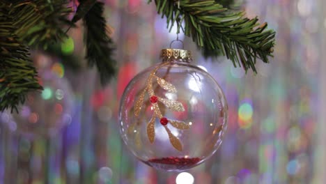 Crystal-christmas-ball-with-red-and-gold-glitter-ornaments-on-tree