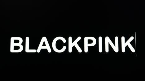 Close-up-of-BLACKPINK-being-typed-into-computer-monitor-screen-with-blinking-cursor-on-black-background-copy-space