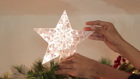 Poner-Decoración-De-Estrellas-Con-Luces-LED-Intermitentes-En-La-Parte-Superior-Del-árbol-De-Navidad.