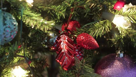 Colocar-Adornos-Rojos-Brillantes-En-Un-árbol-De-Navidad-Decorado-Con-Luces.