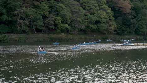Touristen-Genießen-Ein-Ruderboot-Auf-Dem-Katsura-Fluss-In-Arashiyama,-Kyoto