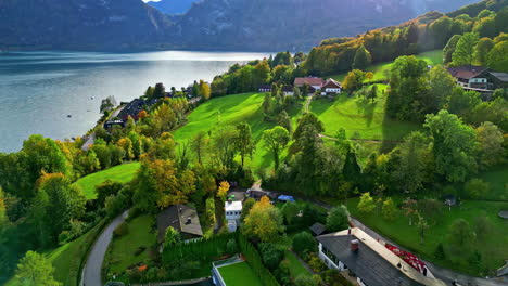 A-picturesque-village-and-farmland-fields-in-autumn-at-Attersee-Lake,-Austria---aerial