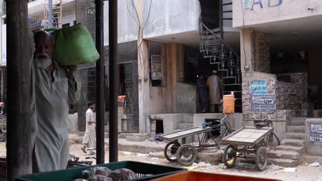 Alte-Männer-In-Weißen-Arbeitern-Tragen-Produkte-Vom-Markt-In-Karatschi,-Pakistan