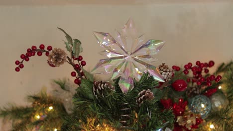 Placing-opalescent-snowflake-star-decoration-on-top-of-christmas-tree
