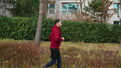Middle-Age-Man-Running-in-Autumn-Park---side-view-slow-motion