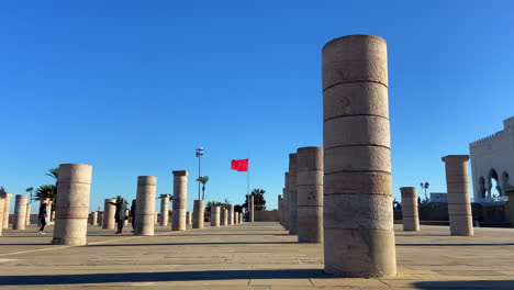 Moroccan-family-enjoying-Hassan-tower-pillars-in-Rabat-with-flag-in-background