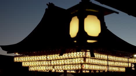 Blurred-View-Of-Illuminated-Hanging-Lantern-With-Background-Shot-Buden-Stage-At-Yasaka,-Kyoto-In-The-Evening