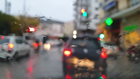 Rain-Drops-in-Front-Screen-of-a-Car-in-City-Traffic