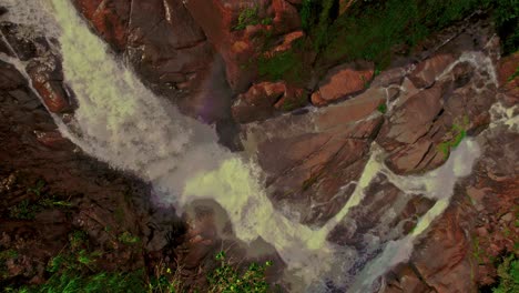 Aerial-top-down-shot-of-waterfall-surrounded-by-rocks-in-Costa-Rica