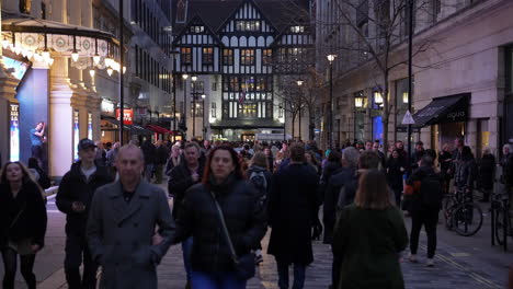 In-slow-motion-crowds-of-Christmas-shoppers-walk-to-and-from-the-Liberty-department-store-near-Regent-Street-at-dusk