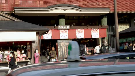 Outside-Entrance-View-To-Arashiyama-Station-WIth-People-And-Traffic-Going-Past