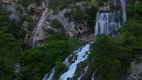 aerial-drone-view-Ujevara-E-Pashtures-wild-waterfalls-in-Nivica-Canyon-with-cliffs-of-karst-gorge