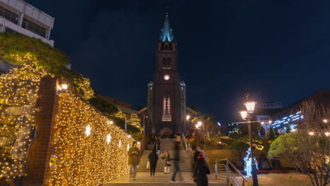 Menschenmenge,-Die-Nachts-Auf-Den-Stufen-Der-Myeongdong-Kathedrale-Spaziert-Und-Weihnachtsdekorationen-Genießt-–-Hyperlapse-Herauszoomen