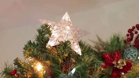 Carelessly-placing-flashing-LED-star-decoration-on-christmas-tree-top