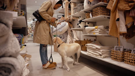A-young-girl-shops-with-her-emotional-support-yellow-Labrador-on-a-leash-at-a-dog-friendly-mall