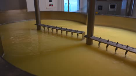 Machines-mixing-milk-in-curd-preparation-tank-at-cheese-factory