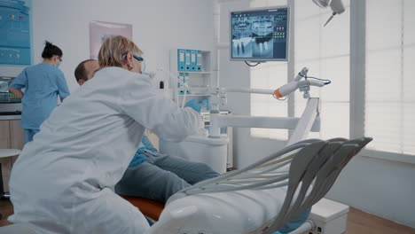 Kieferorthopäde-Zeigt-Auf-Dem-Monitor-Auf-Die-Röntgenaufnahme-Der-Zähne