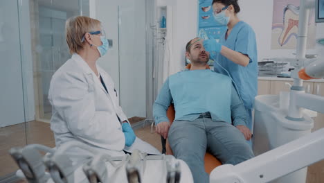Asistente-De-Odontología-Poniendo-Máscara-De-Oxígeno-En-La-Cara-Del-Paciente.